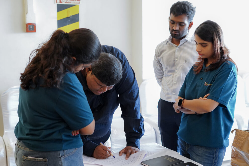A small group reviewing work together over a laptop during a hands-on session at a Bumblebee Inc programme