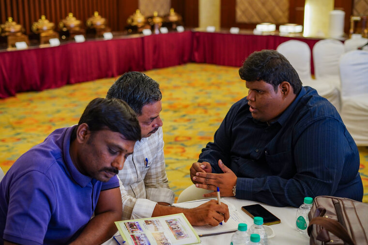 Three people reviewing printed material together at a table